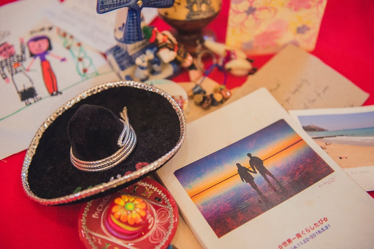 旅先で手に入れた思い出の品々やゲストからプレゼントされたイラストなど。手前にある冊子は、二人の旅の記録を収めたアルバム。