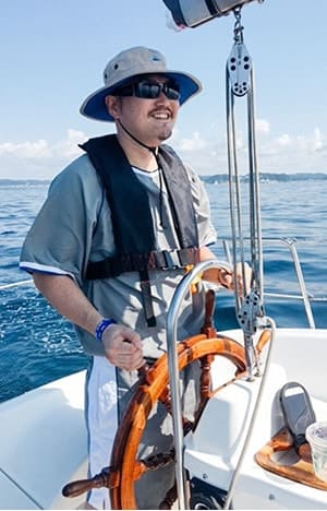 東京湾を背景にヨットでセーリングする