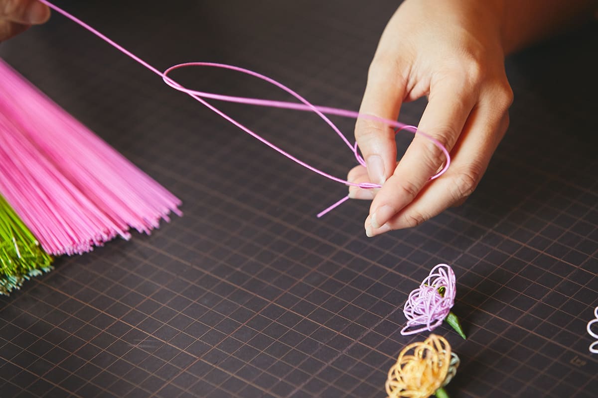 体験では、好きな色の水引を選び、桜・ミニバラ・小菊の中から好きなモチーフを作成していく。